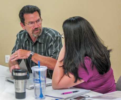 Two folks talking at table