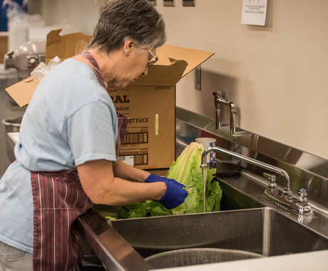 Cafeteria worker washing lettuce
