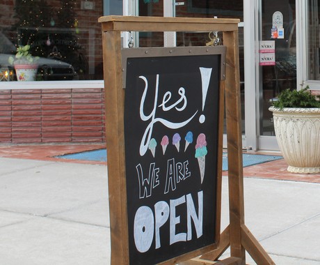 sign that says "Yes! We are open" with drawn ice cream in cones on it
