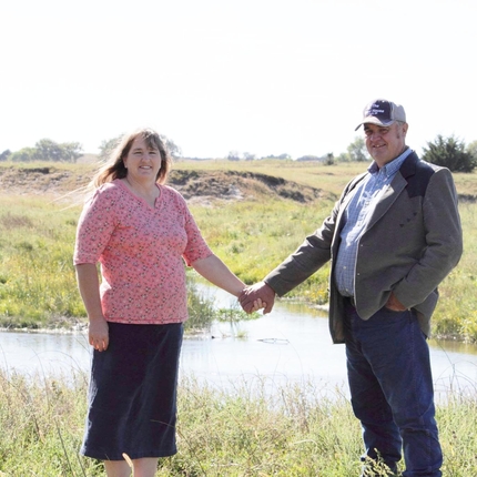 Mujer y hombre posando en el campo.