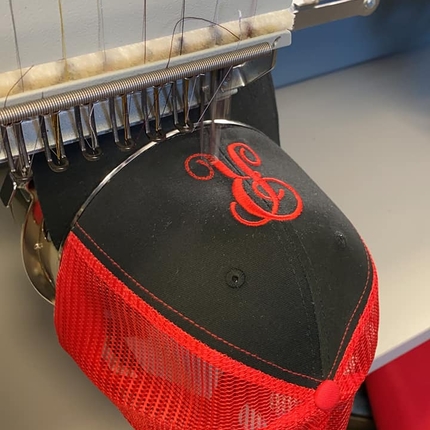 Hat under machine, being embroidered