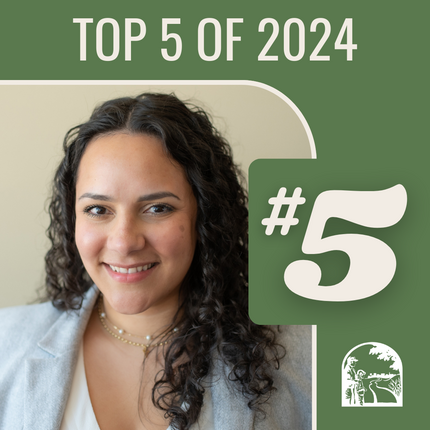 Image that says "Top 5 of 2024 #5", and a photo: Latina woman with curly black shoulder length hair, wearing a grey business jacket with a white shirt underneath and necklaces smiles to the camera