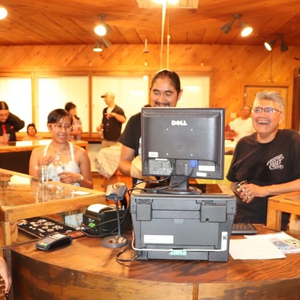 Three men and two women stand behind a register near some jewerly displays