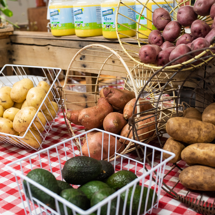 Fresh produce in baskets, russet, red and yukon gold potatoes and avocado