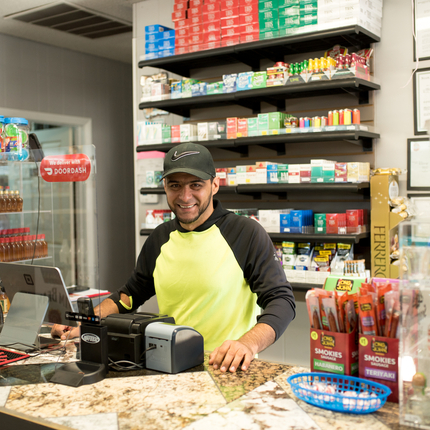 man standing behind counter, smiling