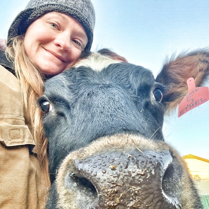 Woman hugging cow, with cow nose almost against camera
