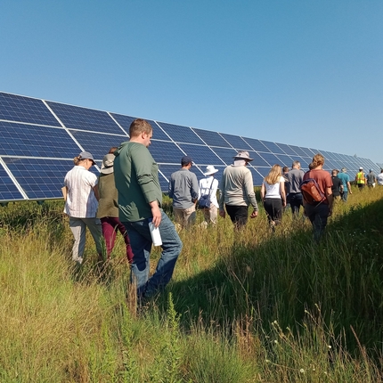 Asistentes caminando junto a paneles solares