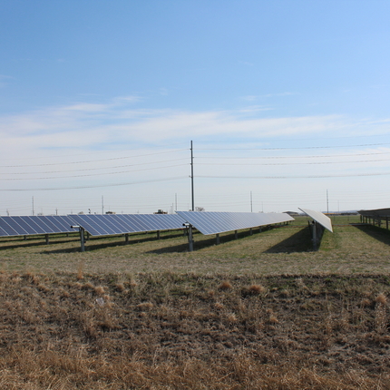 Seis filas de paneles solares en un campo de césped, a finales del otoño. Granja solar comunitaria.