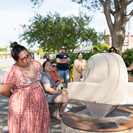 People studying a sculpture in a downtown area