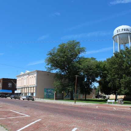Small town main street with buildings and a water tower on the right. 