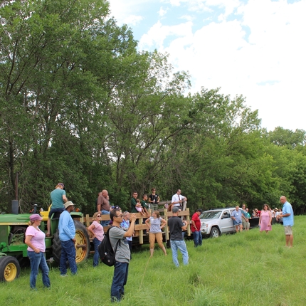 Folks on a hayrack taking a tour of a field