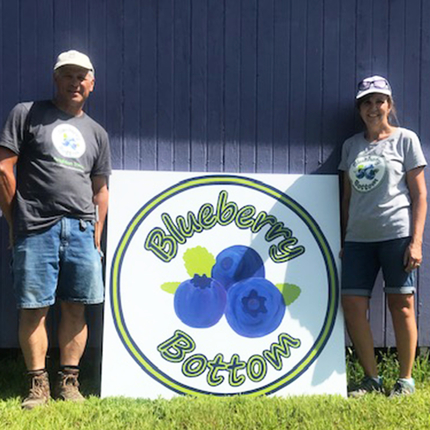 Man and woman with Blueberry Bottom sign