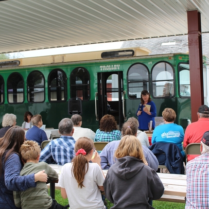 Group watching author present outside of a trolly