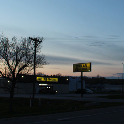 Dollar General building at dusk at edge of town