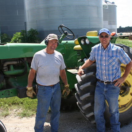 Two farmers in front of their tractor