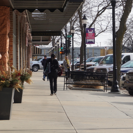 Shoppers walking down a main street with a banner that says "shop the bricks"