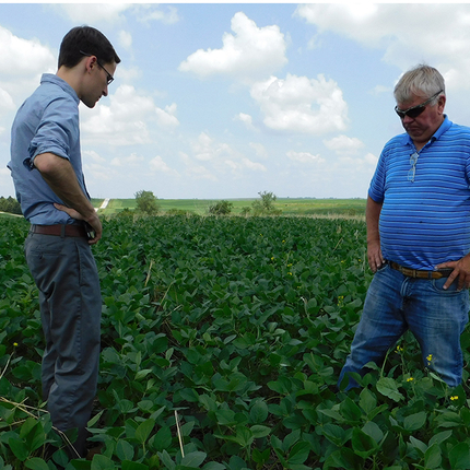 younger man and older man standing in field