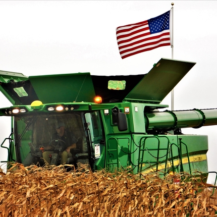 Combine during harvest with American flag