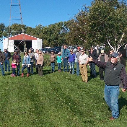 Man leading farm tour in front of barn