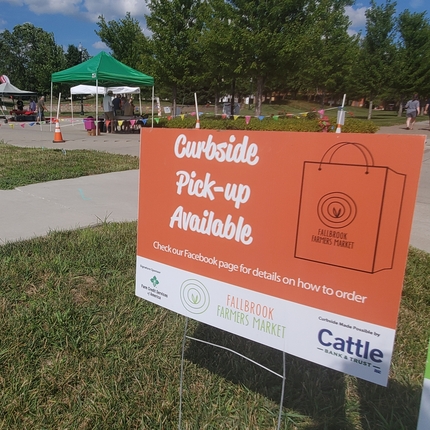 sign for curbside pick-up availability at farmers market