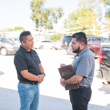 Two men standing and talking outside