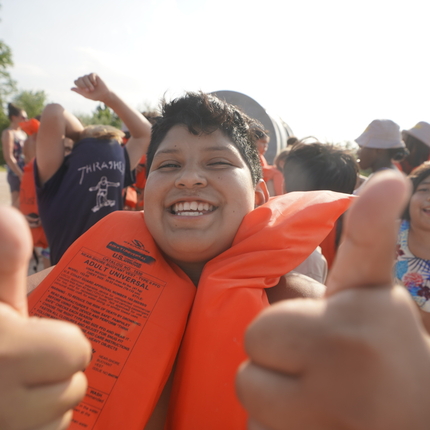 boy with life jacket, giving two thumbs up