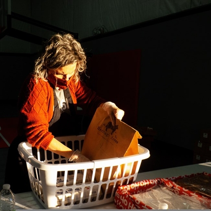 Woman with mask and gloves sorting through products