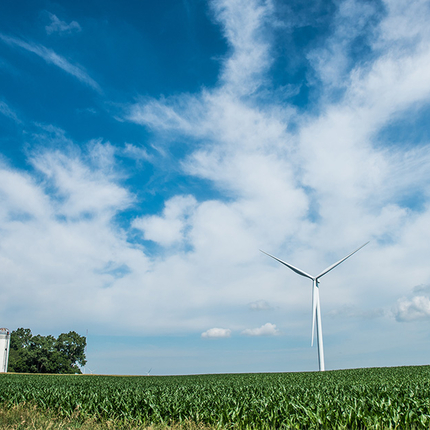wind turbine in field with sky and clouds in background