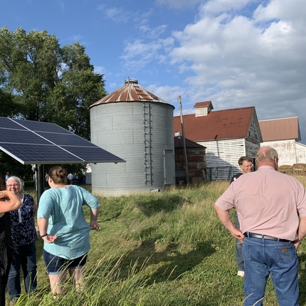 People gathered around solar panels 