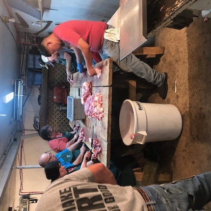 People packaging meat in locker