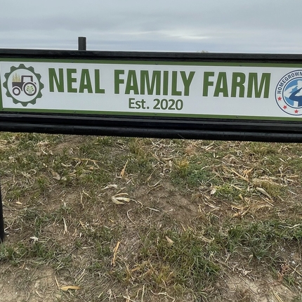 Neal Family Farm sign with black border on land