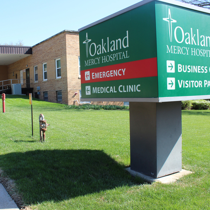 Photo of Oakland Mercy Hospital sign with hospital behind