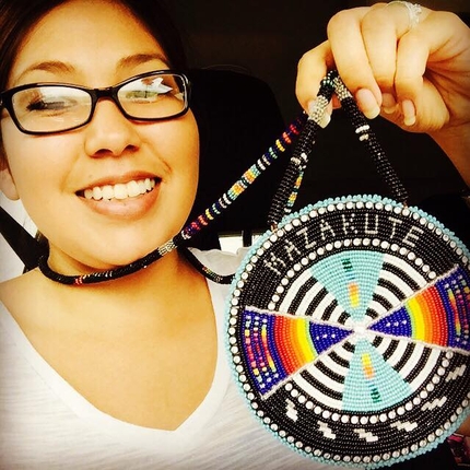 Kady Strickland holding medallion with beadwork