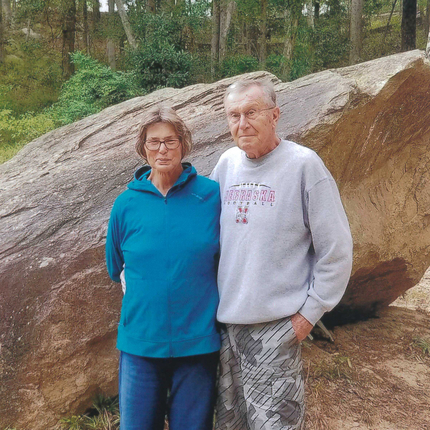 Woman and man standing in front of a rock
