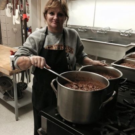 School cafeteria worker with pot of soup