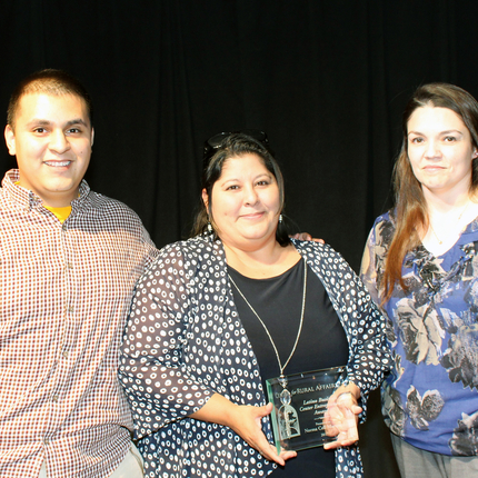 Man and woman receiving award from woman