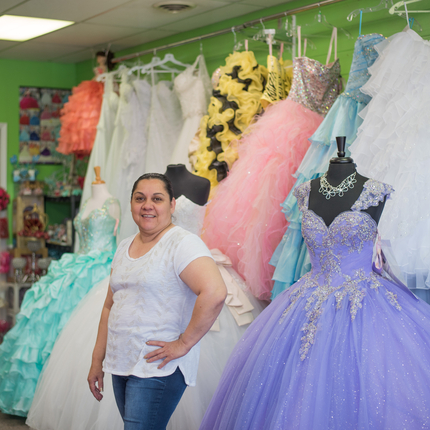 Woman posing in front of dresses