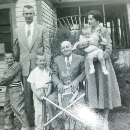 Historical photo: family outside house in rural area