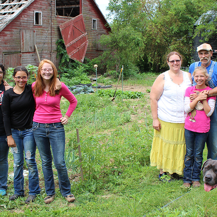 Family in front of barn with dog