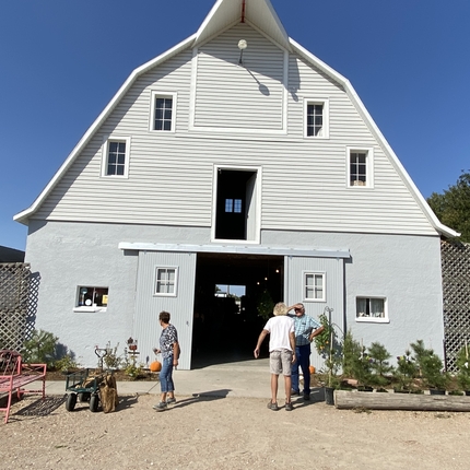 people standing in front of restored white barn