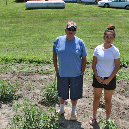 Man and granddaughter standing in garden