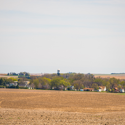 A small town from afar, with a brown field in front