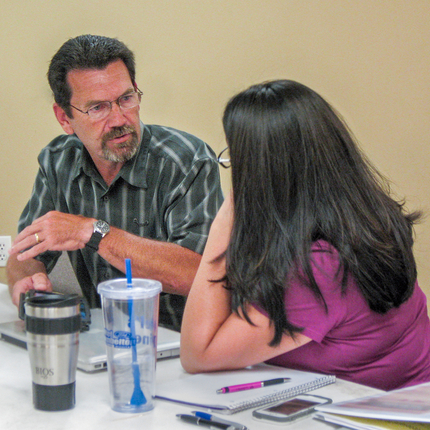Two folks talking at table