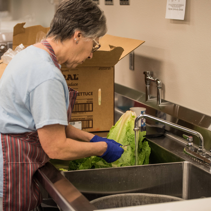 Cafeteria worker washing lettuce