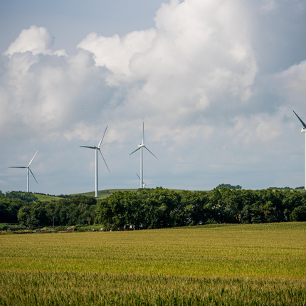 wind turbine in field with sky and clouds in background