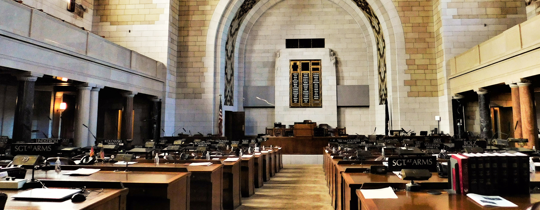 Inside the Nebraska Capitol building. Many tables and chairs with light brick walls.