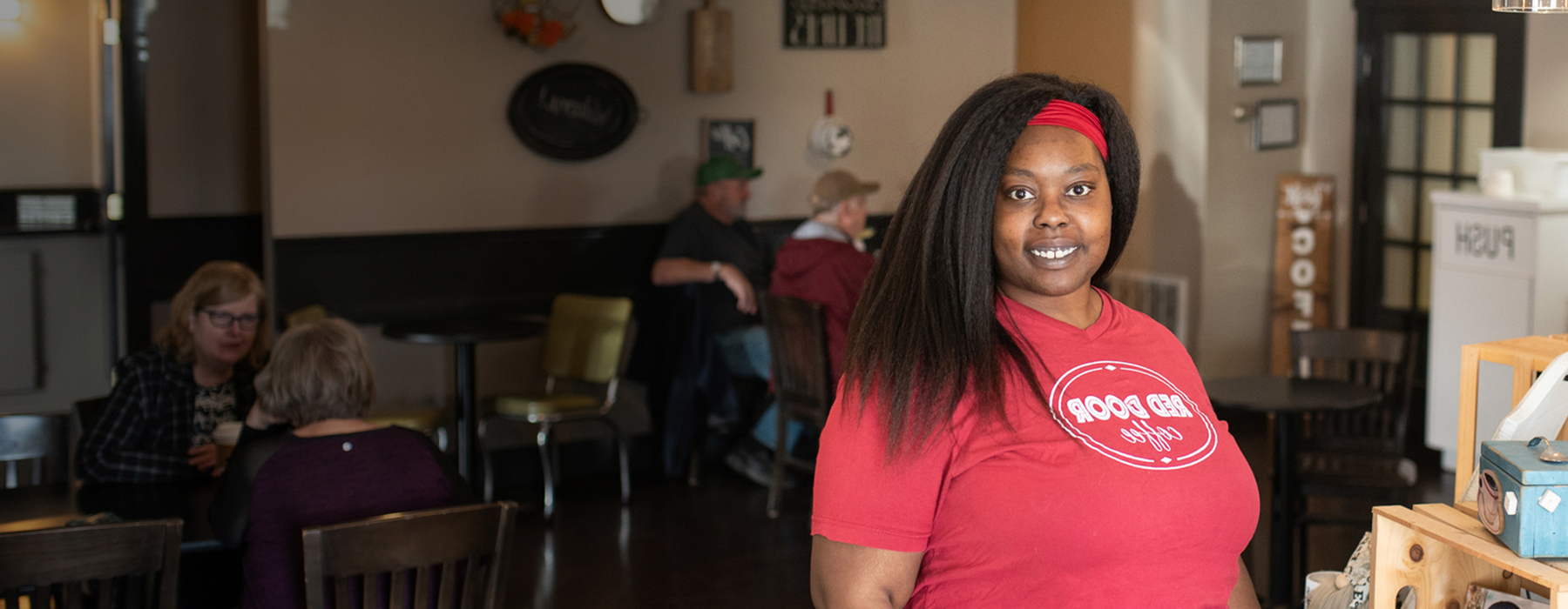 Woman in red shirt stands in coffee shop
